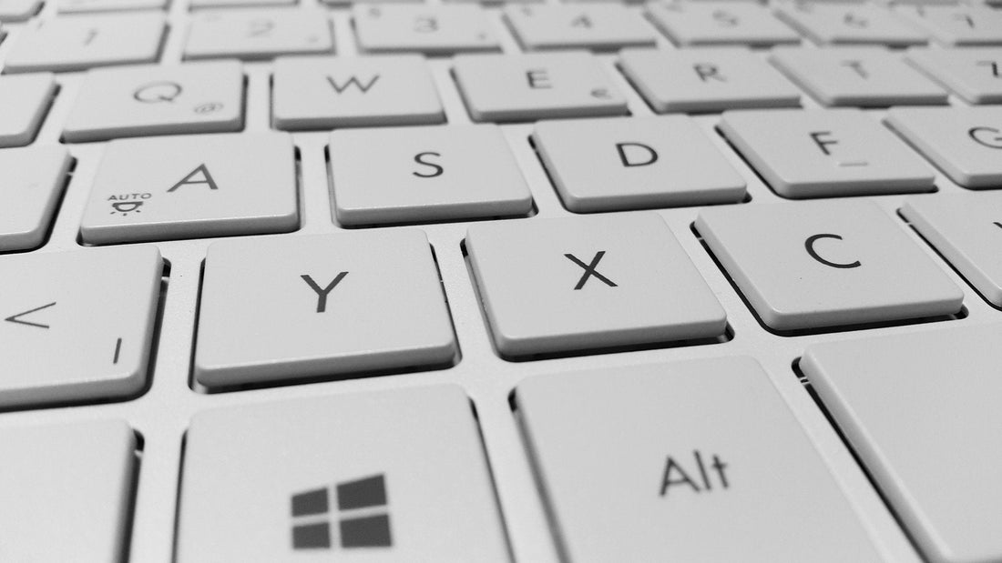 Close-up of a white computer keyboard with clearly visible keys, including letters, Alt, and the Windows logo key.